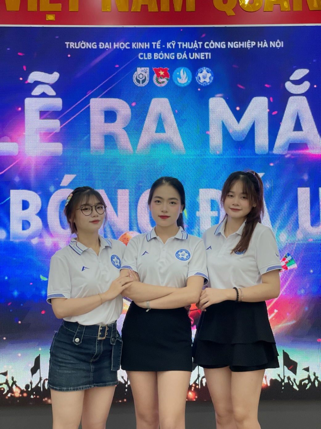 A group of women standing in front of a large sign AI-generated content may be incorrect.
